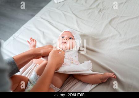 Eine Mutter wickelt ein kaukasisches Baby in Windeln. Der Blick von oben. Das Konzept der Kinderbetreuung und Kindheit. Stockfoto