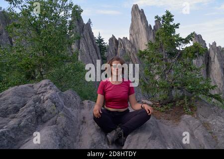 Fröhliche Frau Tourist sitzt auf dem Dach des Felsens Stockfoto