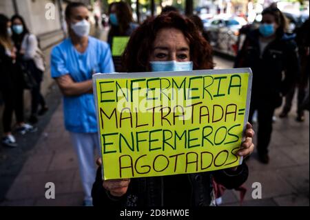 Madrid, Spanien. Oktober 2020. Eine Krankenschwester protestiert mit einem Plakat mit der Aufschrift "misshandelte Krankenschwestern, erschöpfte Krankenschwestern", während Gesundheitsarbeiter im La Princesa Krankenhaus eine Demonstration gegen die mögliche Verlegung von Gesundheitspersonal in das neue Isabel Zendal Notkrankenhaus abhalten, die die Regionalpräsidentin von Madrid Isabel Diaz Ayuso angekündigt hat. Isabel Zendal Emergency Hospital wird in den kommenden Tagen eingeweiht und wird eine Kapazität von 1,000 Betten für Coronavirus (COVID-19) Fälle haben. Quelle: Marcos del Mazo/Alamy Live News Stockfoto