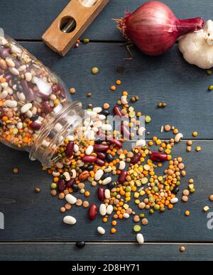 Leguminosen-Pulse mischen sich auf blauem Tischhintergrund. Trockene Mischung für vegetarische gesunde Lebensmittel, italienische Suppenzutaten, Draufsicht Stockfoto