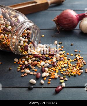 Leguminosen-Pulse mischen sich auf blauem Tischhintergrund. Trockene Mischung für vegetarische gesunde Lebensmittel, italienische Suppenzutaten, Nahaufnahme Stockfoto