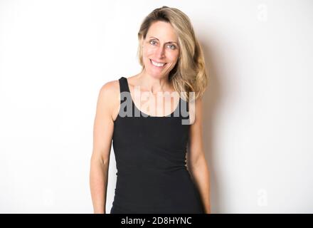 Eine schöne Frau trägt schwarze Tank Top über weißen Studio Wand. Stockfoto