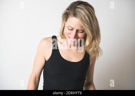 Eine schöne Frau trägt schwarze Tank Top über weißen Studio Wand. Stockfoto