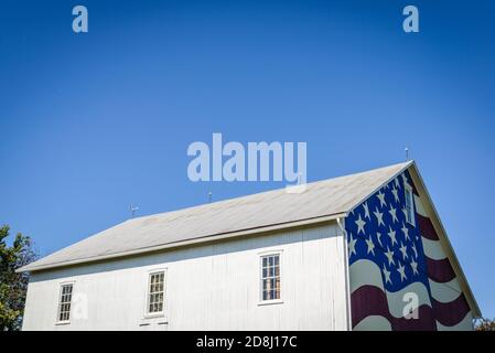 Die amerikanische Flagge (die Sterne und Streifen) auf einer weißen Scheune im ländlichen Zentrum von Pennsylvania, USA. Stockfoto