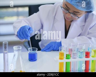 Leitende Wissenschaftlerinnen erwägen ernsthaft die flüssige Lösung in einem Becherglas. Um sich auf das nächste Experiment für die besten Forschungsergebnisse vorzubereiten Stockfoto