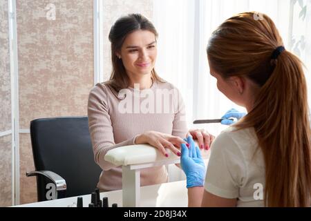 Oung Frau tut Maniküre im Salon. Schönheitskonzept. Stockfoto