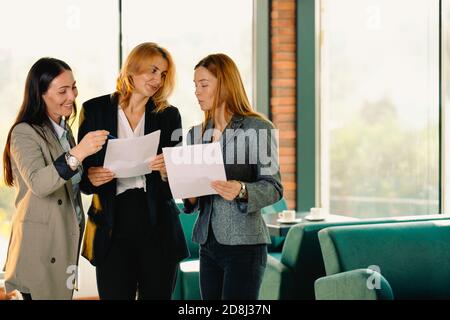 Kolleginnen, junge Geschäftsfrauen in einem modernen Büro diskutieren über einen neuen Businessplan. Teamwork-Konzept Stockfoto