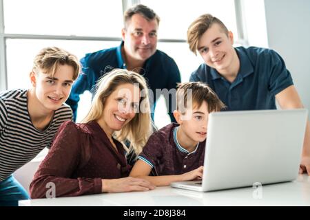 Große Familie, die zu Hause in Computer schaut Stockfoto