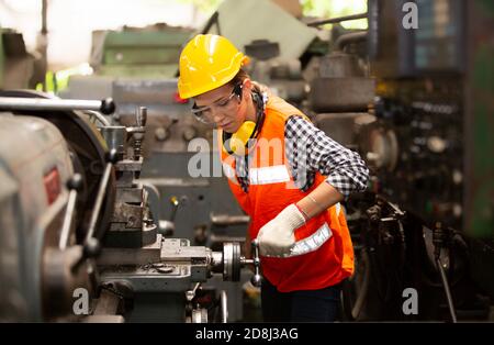 Ingenieurinnen, die eine cnc-Maschine im Werk bedienen Stockfoto