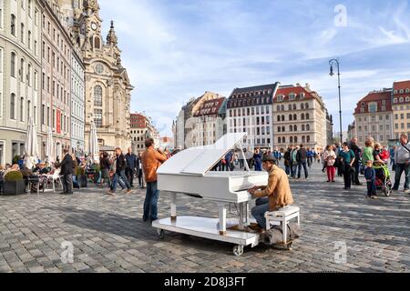 Dresden, Deutschland - 03. Oktober 2015: Ein nicht identifizierter Mann spielt auf einem weißen Flügel auf dem Neumarkt im Zentrum Dresdens Stockfoto