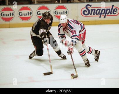 New York Rangers Wayne Gretzky, rechts, 99, nimmt den Puck bis das Eis gegen Los Angeles Kings Steven Finn während eines NHL-Hockey-Spiel im Madison Square Garden am 18. Dezember 1996 in New York. Foto von Francis Specker Stockfoto