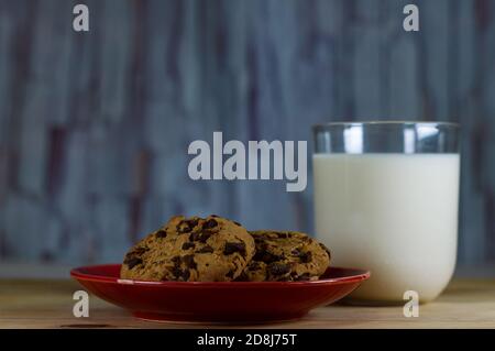 Chocolate Chip Cookies auf rotem Teller und Milch Stockfoto