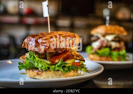 Saftiger und köstlicher Burger mit gegrilltem Rindfleisch, Käse und frischem Gemüse. Stockfoto