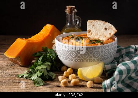 Kürbis Hummus in Schale auf Holztisch Stockfoto