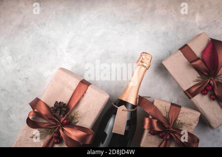 Geschenke und Champagner auf grauem Hintergrund. Stockfoto