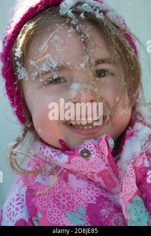 Emotionale Nahaufnahme Porträt von entzückenden weiblichen Kind in warmen Winterkleidung, genießt frische Luft und schönen sonnigen frostigen Tag, glücklich, im Freien zu sein Stockfoto