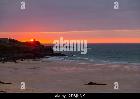 Bild eines Sonnenuntergangs über dem Atlantik, fotografiert von der zerklüfteten Küste von Cornwall bei St. Ives. Das Foto zeigt eine Bucht, Sandstrand, ruhiges Meer, c Stockfoto