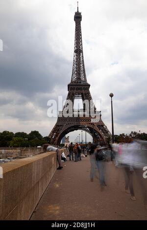 Ein Bild des berühmten Eiffelturms in Paris, Frankreich. Die Langaufnahme wurde an einem bewölkten Tag von einer Brücke über die seine aufgenommen. Leute wal