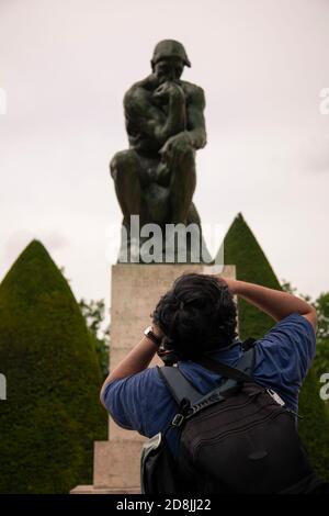 Paris, Frankreich 06/12/2010: Ein Fotograf mit Rucksack macht ein Nahaufnahme der berühmten Denker Statue im Rodin Museum, Paris. Stockfoto