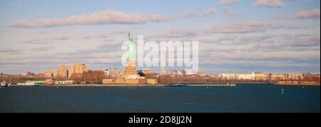 Ein Herbstpanorama, das von der staten Island Fähre aufgenommen wurde, während sie die obere Bucht in Richtung manhattan überquert. Das Bild zeigt die ikonische Freiheitsstatue als Wel Stockfoto