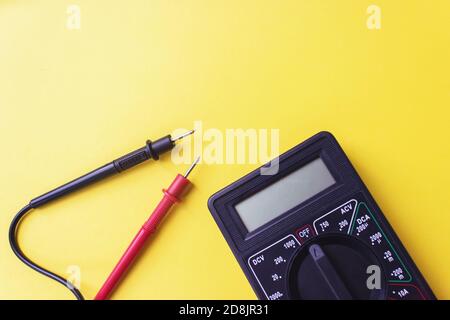 Dunkles Digitalmultimeter mit Messspitzen. Energieeffizienzkonzept Stockfoto