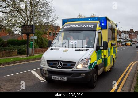 Aylesbury, Buckinghamshire, Großbritannien. Oktober 2020. Sanitäter geben eine Welle, während sie ein "Covid-19 Rising in der Gegend, begrenzen Sie Ihren Kontakt" Straßenrand LED-Zeichen in Aylesbury Stadtzentrum passieren. Quelle: Maureen McLean/Alamy Live News Stockfoto