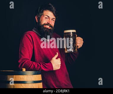 Die Feier oktoberfest Konzept. Retro-Mann mit einem Bier. Bier in Großbritannien. Barkeeper. Holzfass und Glas Bier. Stockfoto