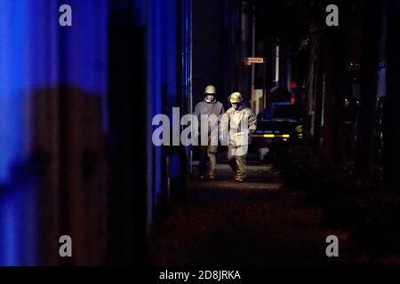 Gelsenkirchen, Deutschland. Oktober 2020. Feuerwehrleute in Schutzanzügen gehen ins Haus, wo in einer Wohnung hochexplosive Chemikalien entdeckt wurden. Verwandte eines verstorbenen Mannes hatten bei der Räumung der Wohnung Picronsäure gefunden. Aus Sicherheitsgründen wurden drei Wohngebäude geräumt. Quelle: Caroline Seidel/dpa/Alamy Live News Stockfoto