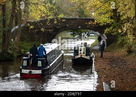 Kanalboote auf dem Coventry Kanal in Atherstone, North Warwickshire. Im Oktober 2020 wurde die Schleuse Nummer zwei auf dem Atherstone-Schleusenflug gebrochen, was dazu führte, dass Boote hochgehalten wurden, wodurch eine Schlange von Booten entstand, die darauf warteten, entlang der Wasserstraße voranzukommen. Stockfoto