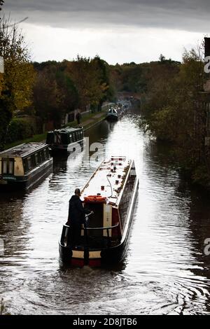 Kanalboote auf dem Coventry Kanal in Atherstone, North Warwickshire. Im Oktober 2020 wurde die Schleuse Nummer zwei auf dem Atherstone-Schleusenflug gebrochen, was dazu führte, dass Boote hochgehalten wurden, wodurch eine Schlange von Booten entstand, die darauf warteten, entlang der Wasserstraße voranzukommen. Stockfoto