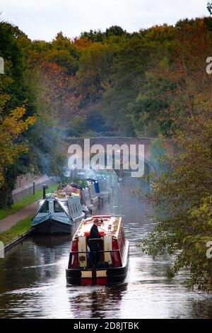 Kanalboote auf dem Coventry Kanal in Atherstone, North Warwickshire. Im Oktober 2020 wurde die Schleuse Nummer zwei auf dem Atherstone-Schleusenflug gebrochen, was dazu führte, dass Boote hochgehalten wurden, wodurch eine Schlange von Booten entstand, die darauf warteten, entlang der Wasserstraße voranzukommen. Stockfoto