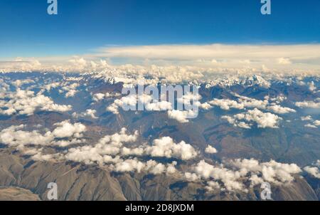 Luftaufnahme des Andenmassivs über Peru, mit verstreuten weißen Wolken darüber Stockfoto