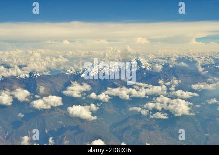 Luftaufnahme des Andenmassivs über Peru, mit verstreuten weißen Wolken darüber Stockfoto