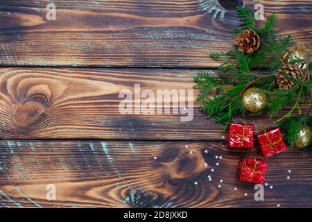 Weihnachtskomposition Spielzeug, Geschenke und Zweige eines Weihnachtsbaumrahmens auf Holzhintergrund Stockfoto
