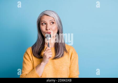 Nahaufnahme Porträt Foto von niedlichen schönen Ruhestand alte Dame verträumt Look lecken Löffel denken vorstellen Essen Familie Abendessen Restaurant tragen Gelber Jumper Stockfoto