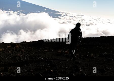 Ein Wandertourist, der einen atemberaubenden Blick auf den Mauna Kea Vulkan auf der Big Island von Hawaii genießt. Stockfoto