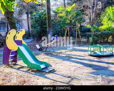 Kinderspielplatz mit Rutsche und verschiedenen Schaukeln in einem Wohnhof Stockfoto