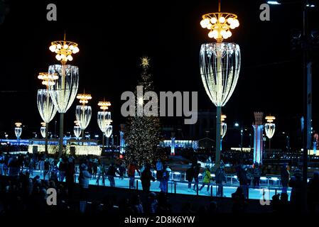 Moskau, Russland - 05. Januar 2020: Die Menschen Schlittschuh auf der VDNH Eisbahn in der Nacht, Unterhaltung in Moskau während der Weihnachtsferien Stockfoto