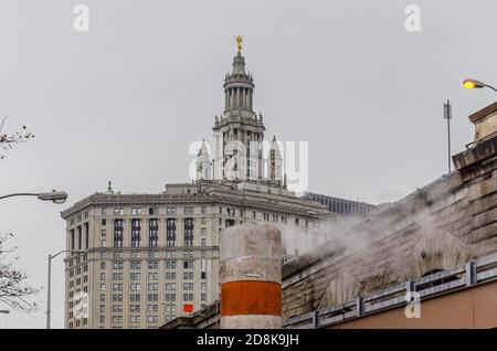 Eine Orange Steam Pipe und New York City Hall Top im Hintergrund, Lower Manhattan, NY, USA Stockfoto