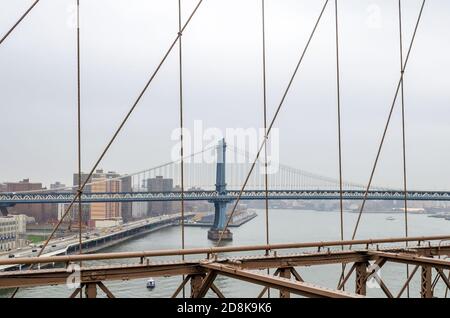 Manhattan New York City bedeckt mit Nebel. Blick Durch Brooklyn Bridge Cables. Lower Manhattan, NY, USA Stockfoto