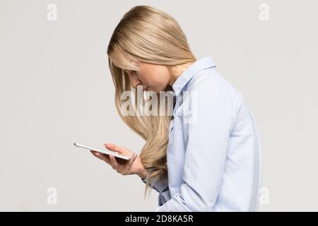 Nahaufnahme Porträt einer jungen Frau mit Handy mit Skoliose, Seitenansicht. Rachiocampsis, Kyphose Krümmung der Wirbelsäule, falsche Haltung, sul Stockfoto