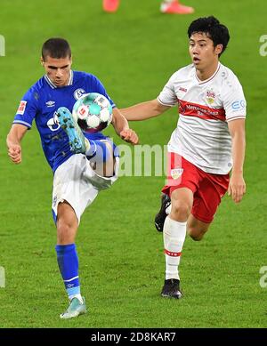 Gelsenkirchen, Deutschland. Oktober 2020. Can Bozdogan (L) von Schalke 04 spielt mit Wataru Endo aus Stuttgart während eines Bundesliga-Spiels zwischen FC Schalke 04 und VfB Stuttgart in Gelsenkirchen, Deutschland, 30. Oktober 2020. Quelle: Christopher Neundorf/Kirchner-Media/Pool/Handout via Xinhua/Alamy Live News Stockfoto