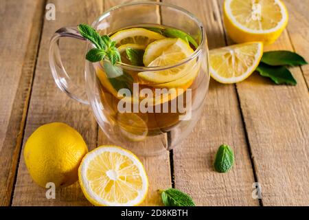 Tee mit Zitrone und Minze in einer transparenten Tasse. Alternative Medizin. Heißes Getränk zur Entspannung. Stockfoto