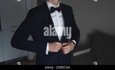 Unkenntlich Mann im eleganten Anzug mit Nackenschleife Schließung der Taste. Hochwertige Fotos Stockfoto