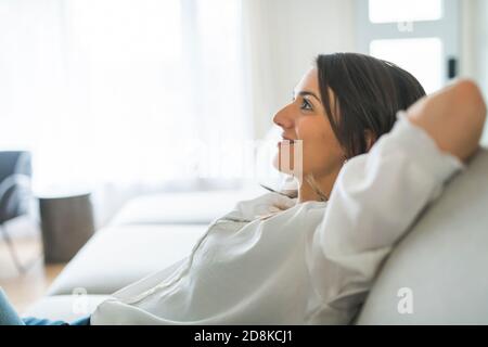 Entspannen Sie Brünette mit gute Zeit auf dem Wohnzimmer Stockfoto