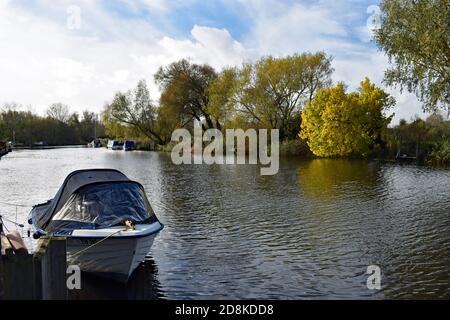 Der Fluss Waveney, wie er eine Kurve durch den Schlepptau von Beccles im Broads National Park, England dreht. Kleine Ausflugsboote liegen am Fluss. Stockfoto