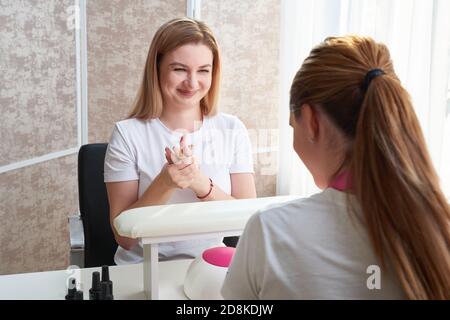 Oung Frau tut Maniküre im Salon. Schönheitskonzept. Stockfoto