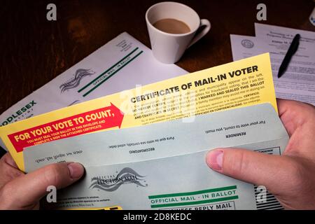 Hände mit offiziellem Briefwahlzettel für die US-Parlamentswahlen 2020; Schwerpunkt auf "WAHLBESCHEINIGUNG" Stockfoto