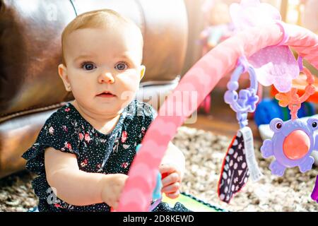 Ein niedliches Baby spielt mit bunten Spielzeug zu Hause Stockfoto