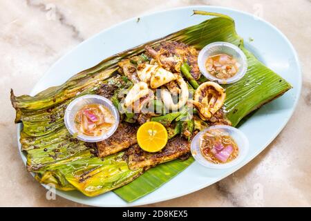 Gegrilltes Fischfilet mit Gewürzen auf Bananenblatt, beliebte malaysische Delikatesse. Stockfoto